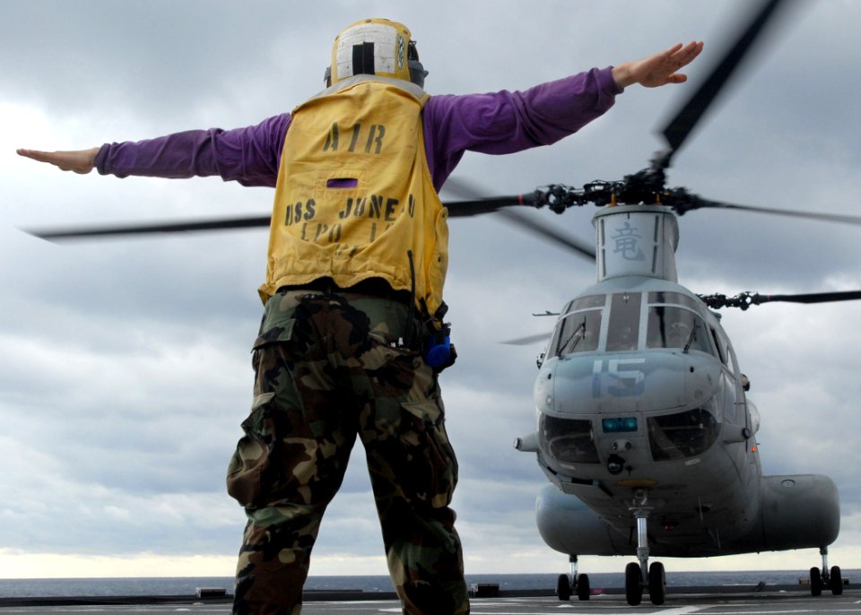 US Navy 070612-N-5067K-085 Aviation Boatswain's Mate Airman Lowel A. Shorey III, a landing signalman enlisted (LSE), signals a Marine CH-46 Sea Knight during take off aboard amphibious transport dock USS Juneau (LPD 10)