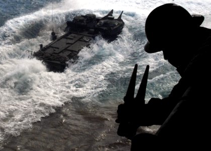 US Navy 070617-N-5067K-137 Boatswain's Mate 2nd Class Arvin A. Ilaccabrera signals a Marine Armored Assault Vehicle (AAV) to the ready position in the well deck of amphibious transport dock USS Juneau (LPD 10) during AAV