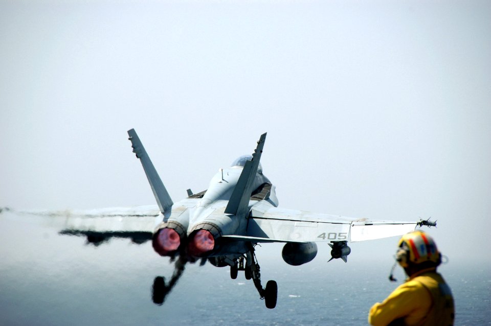 US Navy 070613-N-0890S-005 A Sailor watches as an F-A-18C Hornet assigned to the Sunliners of Strike Fighter Squadron (VFA) 81 launch from the flight deck of the nuclear-powered aircraft carrier USS Nimitz (CVN 68)