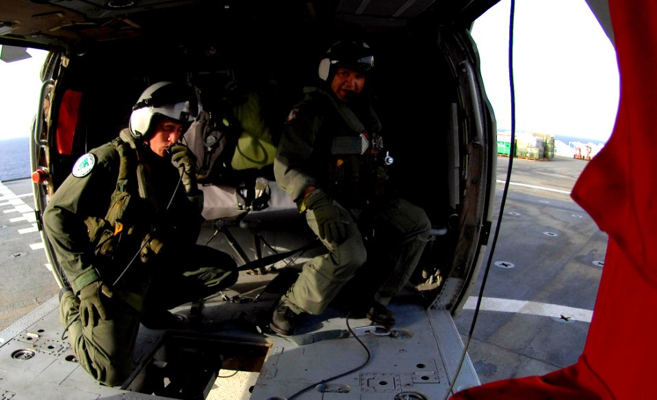 US Navy 070618-N-6278K-029 Aviation Warfare Systems Operator 3rd Class Eric Rockwell and Aviation Warfare Systems Operator 1st Class Carlos Hernandez inspect the cargo hook on a MS-60S helicopter