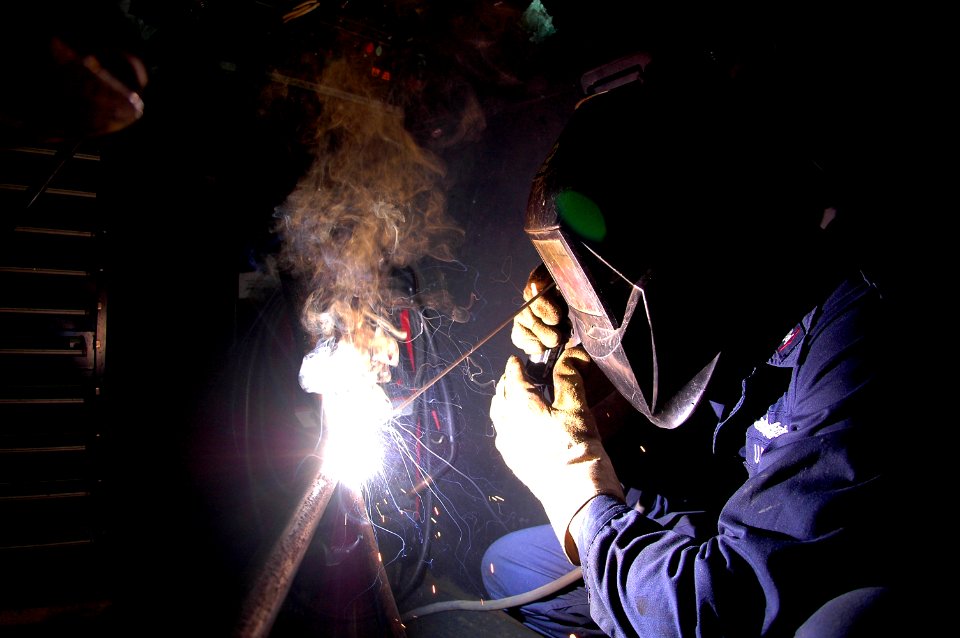 US Navy 070612-N-9760Z-015 Hull Maintenance Technician 3rd Class William Clark welds a metal frame in the machinery shop aboard nuclear-powered aircraft carrier USS Nimitz (CVN 68)