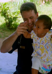 US Navy 070620-N-0120A-091 Dock landing ship USS Harpers Ferry (LSD 49) medical doctor Lt. Terrence M. Kilfoil plays with a Thai toddler after a check-up during a medical civil action project at the Choom Chon Wat Suwan Rungsun
