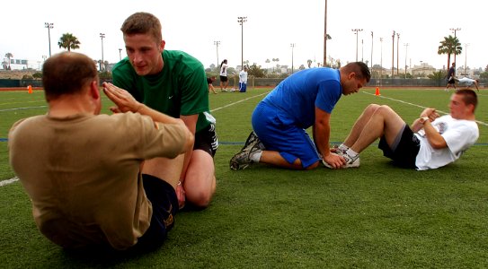 US Navy 070615-N-4163T-093 Sailors take turns completing a total of 60 sit-ups during the Naval Base San Diego and Navy Region Southwest Moral, Welfare and Recreation (MWR) 2nd Annual Backyard Fitness Challenge