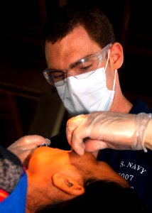 US Navy 070620-N-0120A-101 Dock landing ship USS Harpers Ferry (LSD 49) dental doctor Lt. Adrian LePendu gives a local anesthetic to a Thai woman before a dental procedure