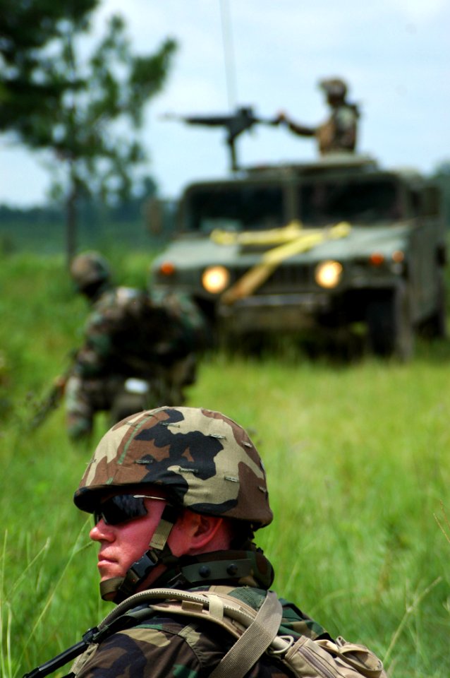 US Navy 070620-N-7367K-005 Seabees with Naval Mobile Construction Battalion (NMCB) 1 secure a perimeter while other Seabees continue setting up camp and working on the medium girder bridge