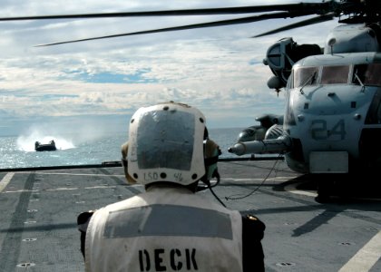 US Navy 070620-N-6710M-031 A landing craft air cushion (LCAC) prepares to enter the well deck while awaiting the departure of a CH-53 Sea Stallion on the flight deck of dock landing ship USS Tortuga (LSD 46) while conducting Ta
