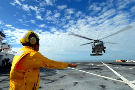 US Navy 070617-N-8704K-045 Aviation Boatswain's Mate (Handling) 3rd Class Luis Dominguez signals an MH-60S Seahawk aboard Military Sealift Command hospital ship USNS Comfort (T-AH 20) photo