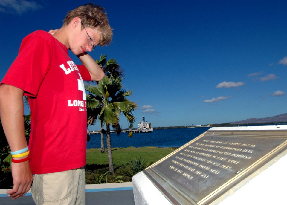 US Navy 070619-N-9758L-003 Nathaniel Allen reads the memorial plaque at the USS Utah (BB 31) memorial site at Ford Island during a private tour sponsored by the Make-A-Wish Foundation