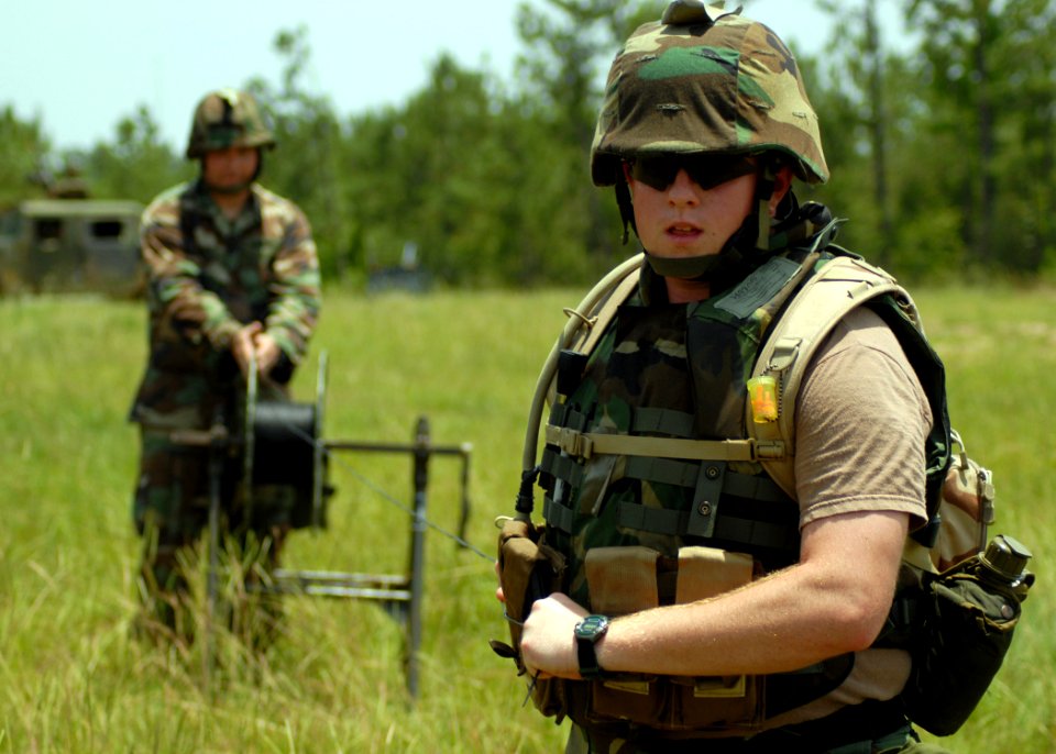 US Navy 070619-N-3857R-004 Personnel Serviceman 3rd Class Ray Guedry assigned to Naval Mobile Construction Battalion (NMCB) 1 pull communications wire across the battalion's forward operating base at Camp Shelby
