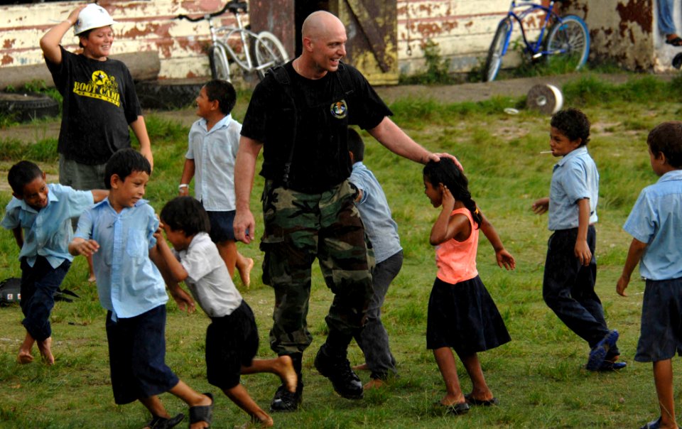 US Navy 070622-N-6278K-008 Air Force Tech. Sgt. Michael Cooper, a member of Construction Battalion Maintenance Unit (CBMU) 202, plays with children at Monsignor Romero Roman Catholic School in the Valley of Peace