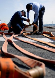US Navy 070619-N-7981E-102 Members air department aboard Nimitz-class aircraft carrier USS Abraham Lincoln (CVN 72) ready fire hoses for hydrostatic testing as part of a planned maintenance performed on the ship's flight deck photo