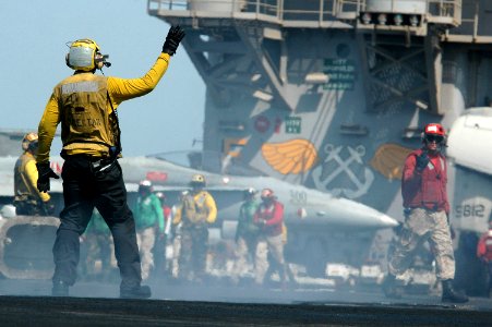 US Navy 070622-N-9760Z-027 A flight deck director signals an aircraft during flight operations on the flight deck of the nuclear-powered aircraft carrier USS Nimitz (CVN 68)