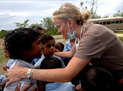 US Navy 070622-N-6278K-003 Air National Guardsman Senior Airman Holly Moore plays with children at Monsignor Romero Roman Catholic School photo