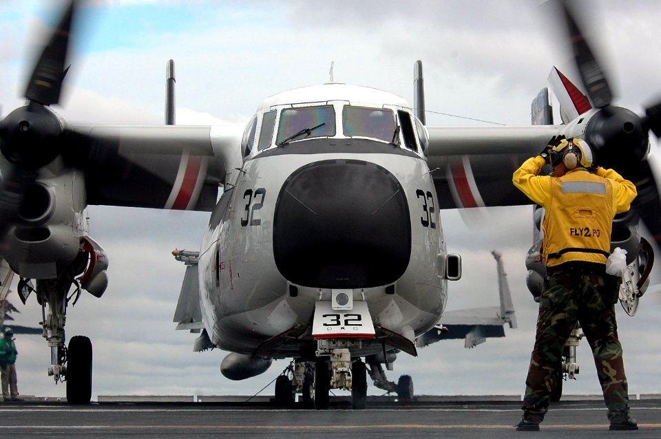 US Navy 070619-N-7883G-053 An aircraft director taxis a C-2A Greyhound assigned to Carrier Logistics Support Squadron (VRC) 30 aboard USS Kitty Hawk (CV 63)