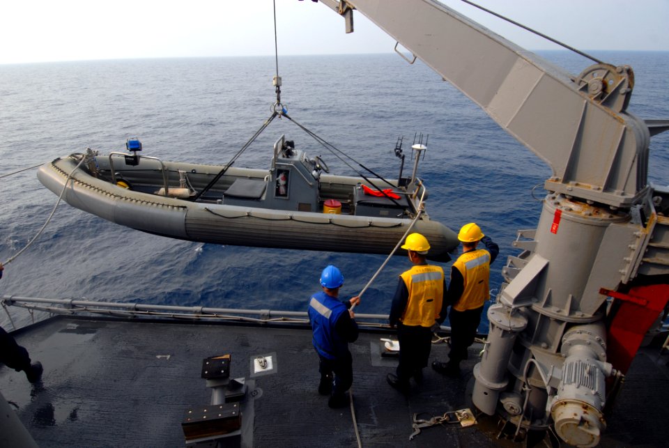 US Navy 070623-N-0841E-043 Sailors on board guided-missile cruiser USS Vicksburg (CG 69) lower a rigid hull inflatable boat (RHIB) into the water before taking part in a boarding scenario training exercise