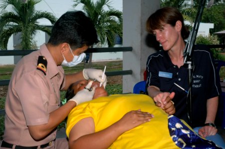 US Navy 070619-N-7783B-001 A Royal Thai Army dentist gives a numbing shot to a local citizen, while Lt. Karen Wiebe, assigned to Operational Health Support Unit Detachment Lima Great Lakes, comforts her