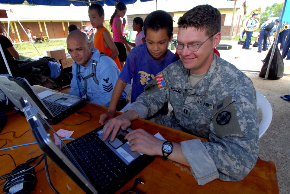 US Navy 070623-N-8704K-046 U.S. Army Capt. John Wishart, attached to the Military Sealift Command hospital ship USNS Comfort (T-AH 20), communicates with the ship as a young child watches