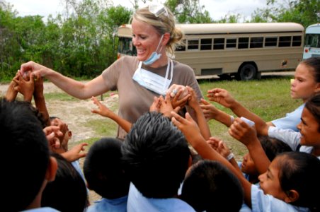 US Navy 070622-N-0194K-579 Air Force Senior Airman Holly Moore from the 123 Medical Dental Air National Guard, plays with children at the Monsignor Romero Roman Catholic School