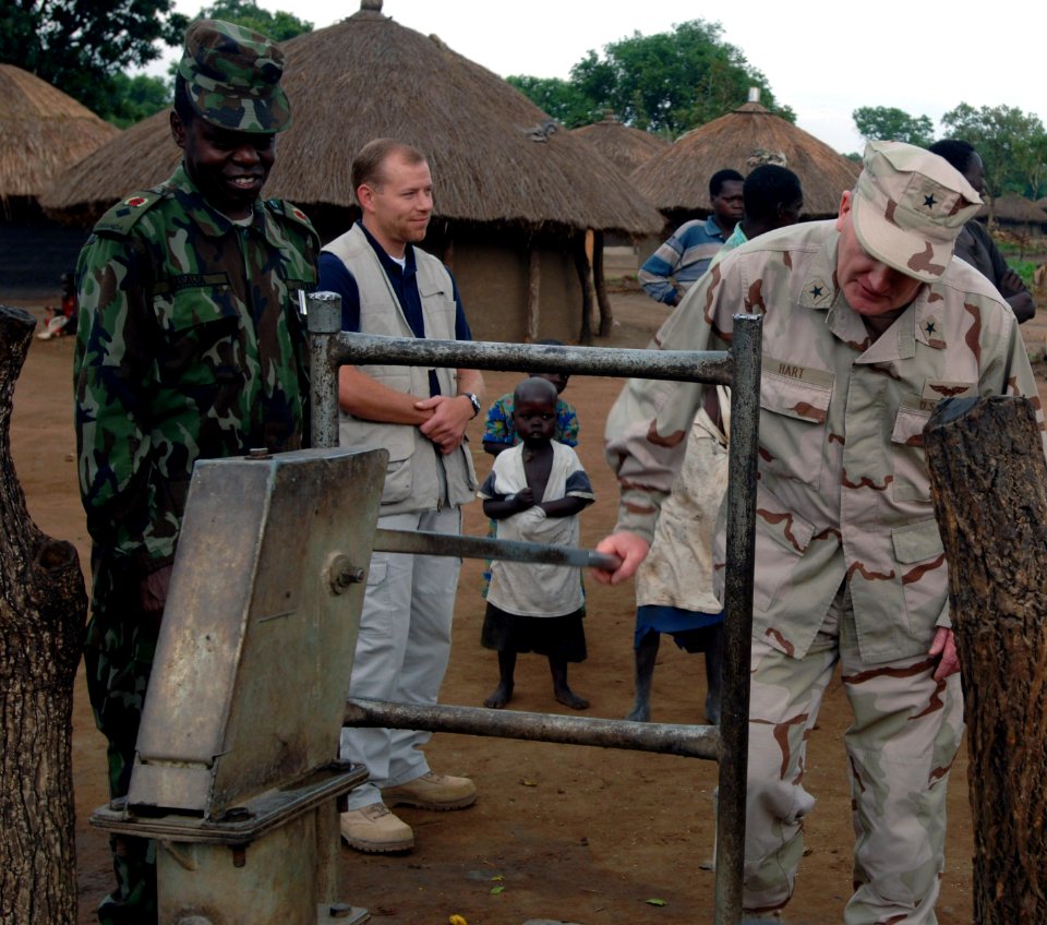 US Navy 070619-N-1003P-022 Commander, Combined Joint Task Force-Horn of Africa, Rear Adm. James Hart fills up a water jug for a family in the Internally Displaced Persons Camp