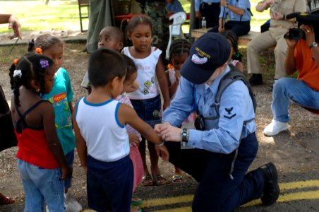US Navy 070622-N-7088A-037 Hospital Corpsman 3rd Class Karmen Hickey, stationed at Naval Medical Center Portsmouth, Va., fastens wristbands to children at the Price Barracks in Ladyville photo