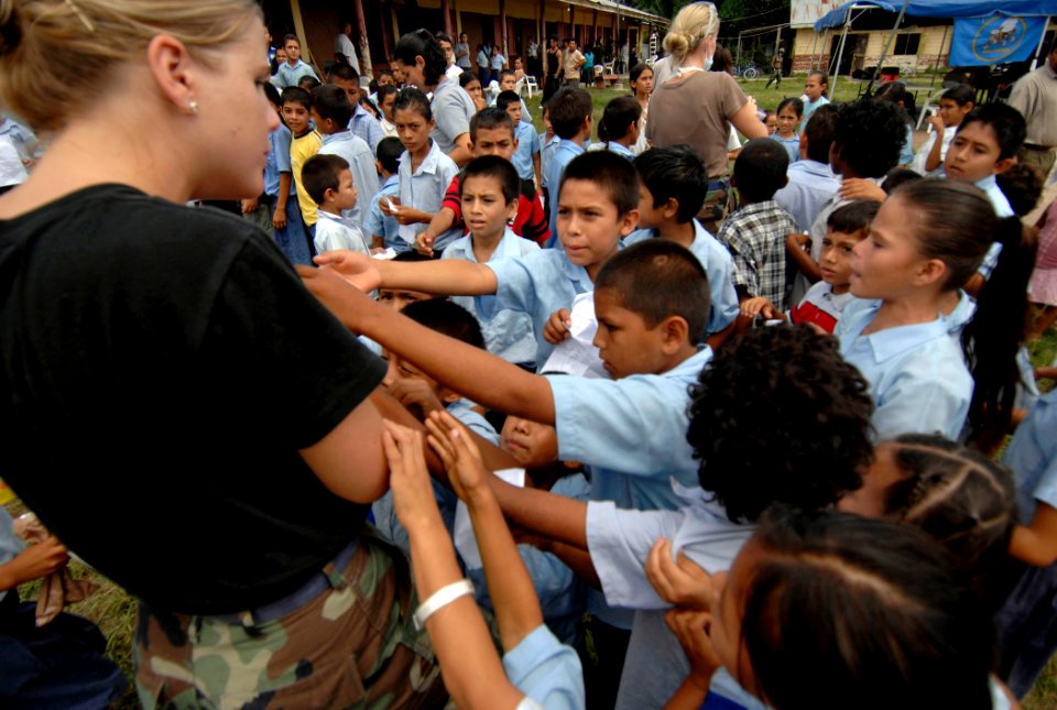 US Navy 070622-N-6278K-004 Air National Guardsman Staff Sgt. Sarah Boyll hands out toys to children at Monsignor Romero Roman Catholic School