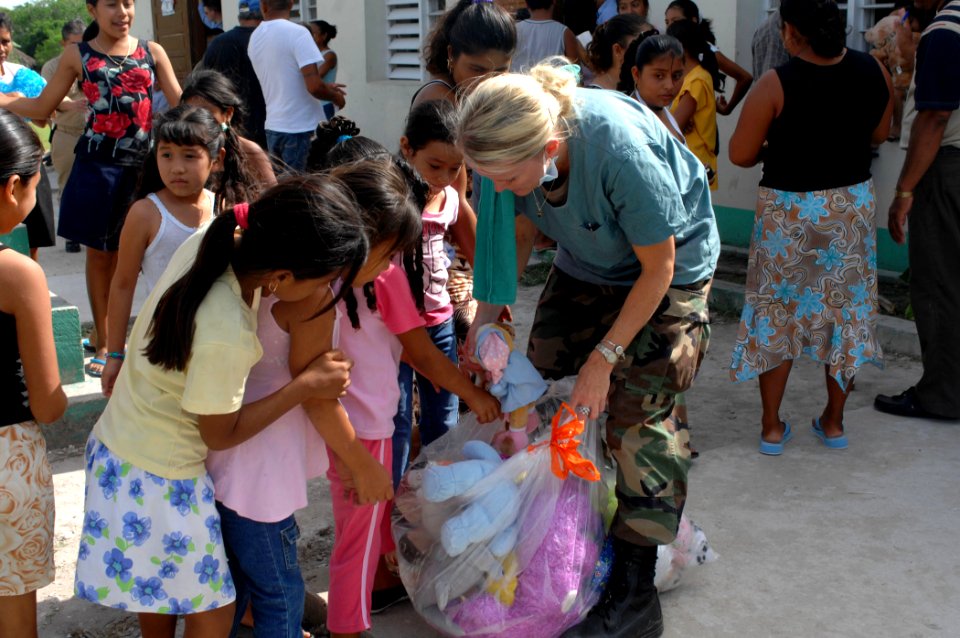 US Navy 070624-N-7088A-015 Air National Guardsman Senior Airman Holly Moore from the Military Sealift Command hospital ship USNS Comfort (T-AH 20) passes out toys to children in need of dental care