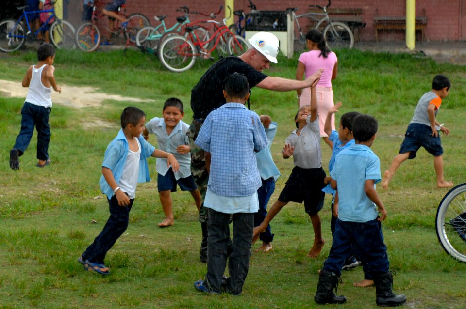 US Navy 070622-N-0194K-740 Air Force Tech. Sgt. Michael Cooper, attached to Seabee Construction Maintenance Unit 202 Detachment plays with children at the Monsignor Romero Roman Catholic School