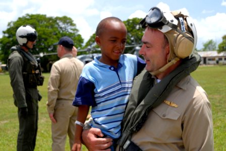 US Navy 070622-N-4238B-064 Capt. Bob Kapcio, Comfort mission commander, holds a young boy from Belize City, Belize photo
