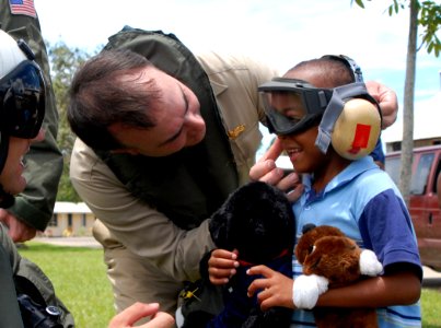 US Navy 070622-N-4238B-093 Capt. Bob Kapcio, USNS Comfort (T-AH 20) mission commander, adjusts the headgear of a local child