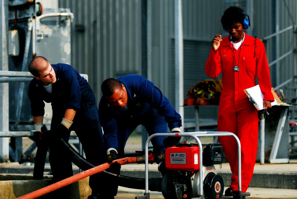 US Navy 070626-N-1688B-403 Damage Controlman 2nd Class Breanna Witherspoon watches for mistakes while timing Sailors on an event using the P-100 fire pump