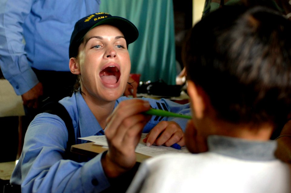 US Navy 070622-N-0194K-296 Hospital Corpsman 2nd Class Tali Brewer examines a patient at the Monsignor Romero Roman Catholic School in the Valley of Peace