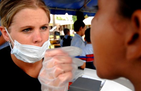 US Navy 070622-N-6278K-006 Air National Guardsman Staff Sgt. Sarah Boyll applies fluoride to a child's teeth at Monsignor Romero Roman Catholic School
