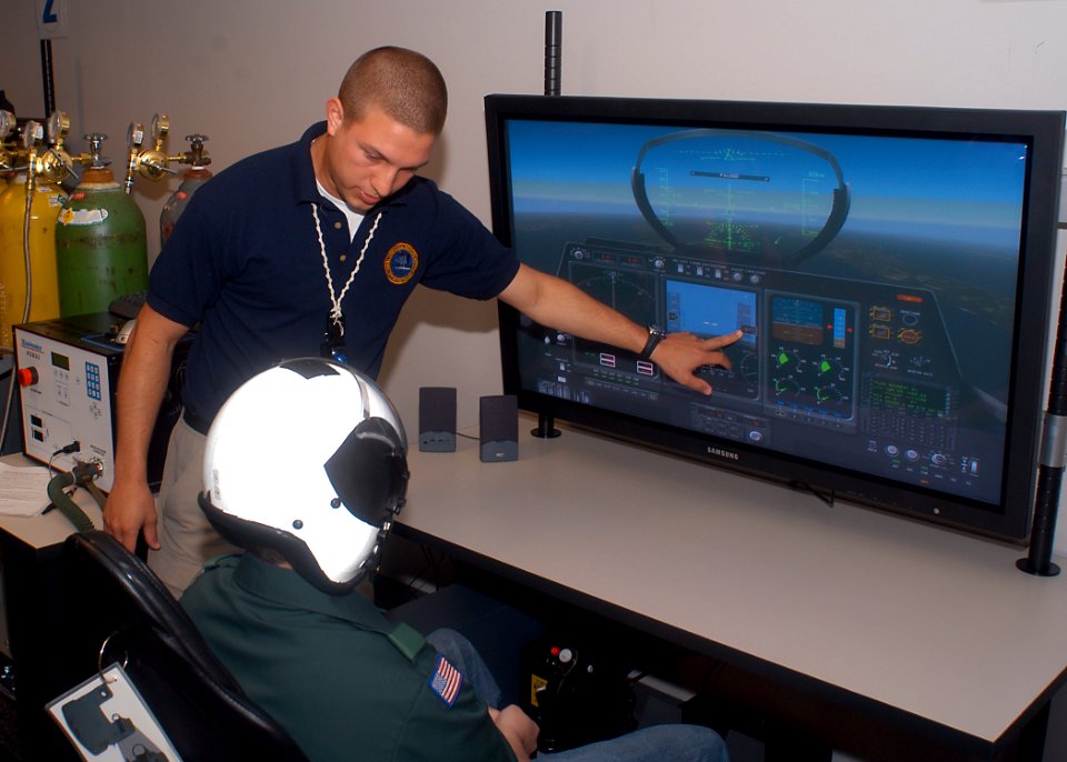 US Navy 070626-N-6247M-008 Hospital Corpsman 2nd Class Brandon McMahan, from Indianapolis, shows a Boy Scout the aircraft simulator used with reduced oxygen breathing device (ROBD)