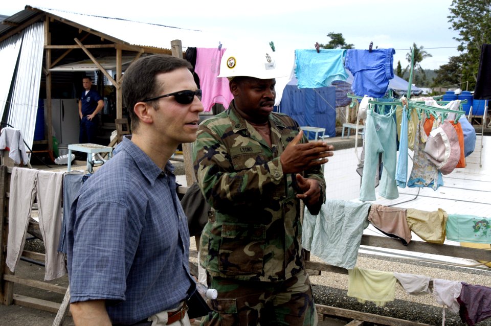 US Navy 070623-N-6410J-021 Principal Director, Assistant Secretary of Defense for Partnership Strategy, Mr. Todd Harvey listens to a brief from Chief Utilitiesman Clinton Lyons about the construction site being repaired by Seab