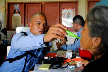 US Navy 070622-N-0194K-447 Hospital Corpsman 3rd Class Philip Ganaban checks the vital signs of a patient at the Monsignor Romero Roman Catholic School in the Valley of Peace photo