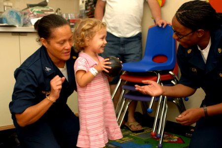 US Navy 070623-N-7088A-036 Capt. Wanda Richards and Chief Hospital Corpsman Tracey Lewis play with a young child in a playroom aboard the Military Sealift Command hospital ship USNS Comfort (T-AH 20)