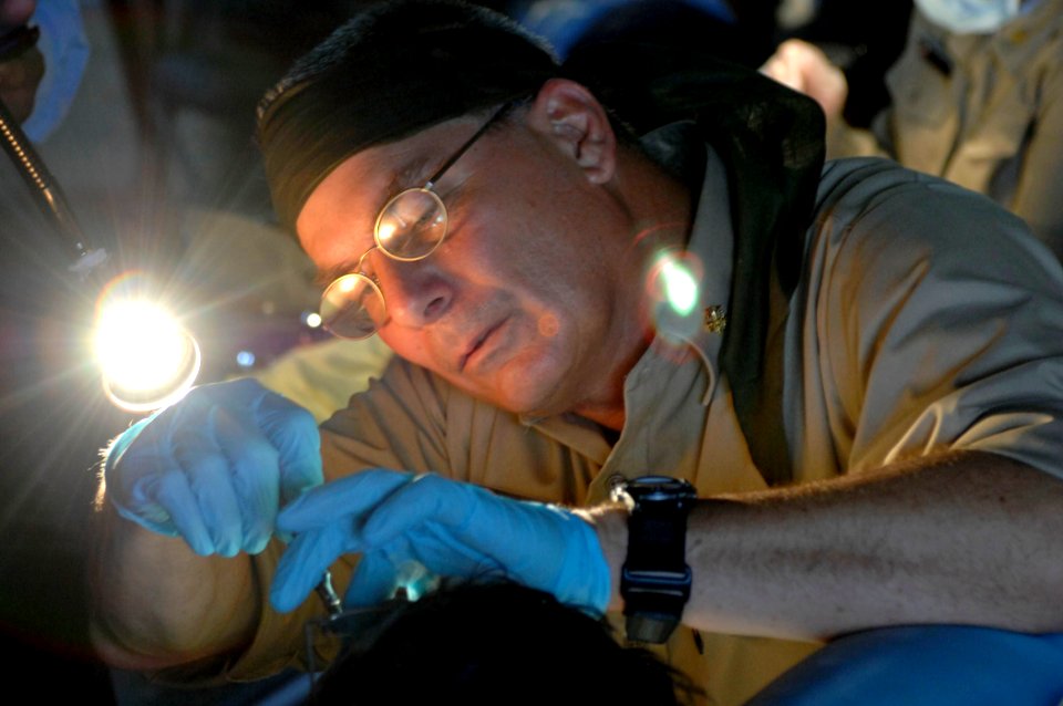 US Navy 070622-N-0194K-743 Cmdr. Steven Johnson with U.S. Public Health Service provides dental care for a patient at the Monsignor Romero Roman Catholic School
