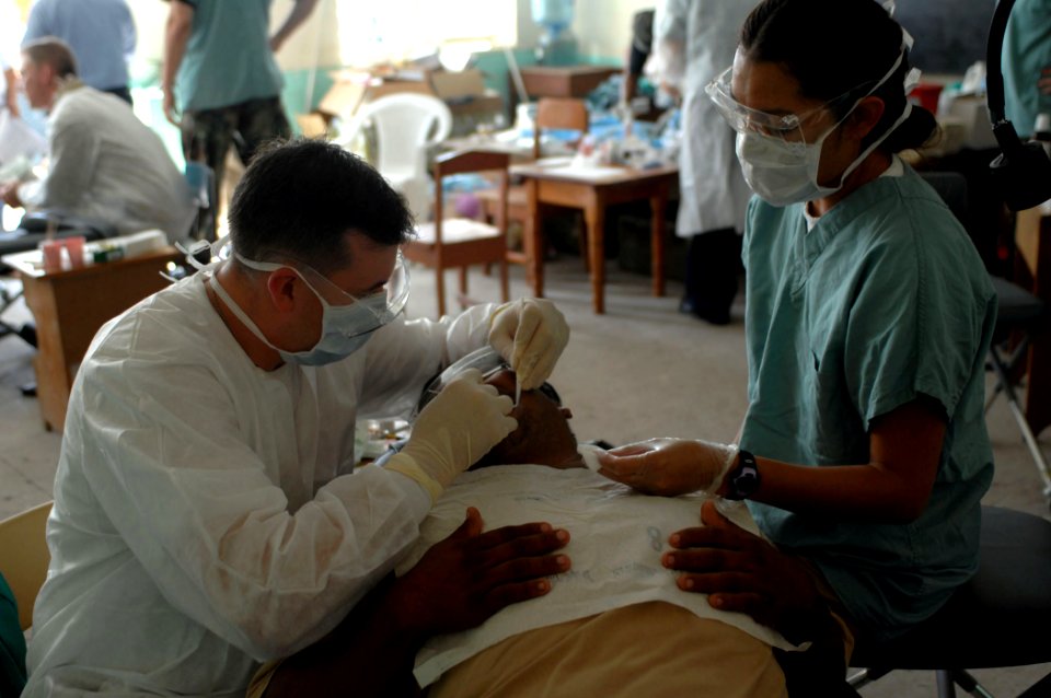 US Navy 070624-N-7088A-001 Lt. j.g. Joseph Shurina and Lt. j.g. Lisa Begay, both members of the U.S. Public Health Service, assigned to the Military Sealift Command hospital ship USNS Comfort (T-AH 20), provide dental care for