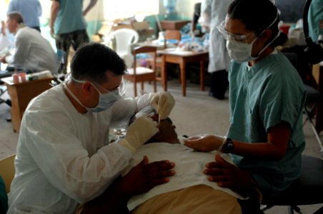 US Navy 070624-N-7088A-001 Lt. j.g. Joseph Shurina and Lt. j.g. Lisa Begay, both members of the U.S. Public Health Service, assigned to the Military Sealift Command hospital ship USNS Comfort (T-AH 20), provide dental care for