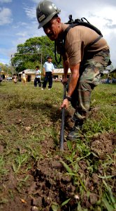 US Navy 070622-N-6278K-007 Equipment Operator 1st Class Manuel Gradillas, a member of Construction Battalion Maintenance Unit (CBMU) 202, digs a drainage trench