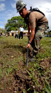 US Navy 070622-N-6278K-007 Equipment Operator 1st Class Manuel Gradillas, a member of Construction Battalion Maintenance Unit (CBMU) 202, digs a drainage trench photo