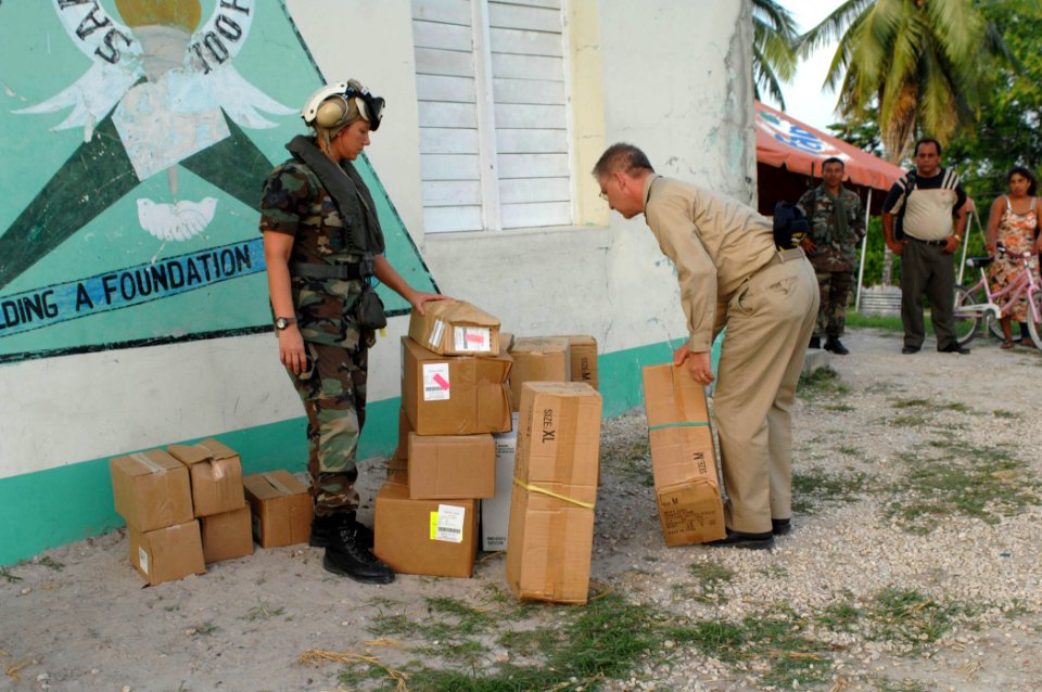 US Navy 070624-N-7088A-019 Staff Sgt. Monica Christman and Capt. Joseph Rusz, both attached to the Military Sealift Command hospital ship USNS Comfort (T-AH 20), organize boxes of supplies donated by Project Handclasp