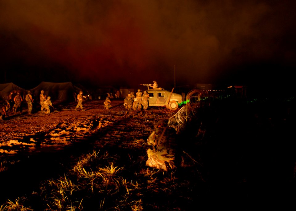 US Navy 070627-N-3857R-001 Seabees assigned to Naval Mobile Construction Battalion (NMCB) 1 are illuminated by a simulated mortar blast at Camp Shelby, Miss