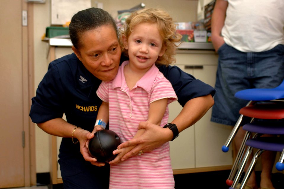 US Navy 070623-N-7088A-037 Capt. Wanda Richards plays with child in a playroom aboard the Military Sealift Command hospital ship USNS Comfort (T-AH 20) following surgery