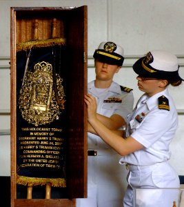 US Navy 070624-N-5345W-210 Lt. Elizabeth Steffen, right, and Lt. Julia Weber close the door of the ark protecting a Jewish Torah at the conclusion of the Torah dedication ceremony in the hangar bay of the Nimitz-class aircraft