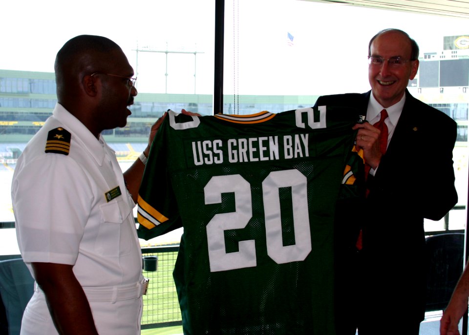 US Navy 070625-N-7163S-006 Prospective commanding officer of Precommssioning Unit (PCU) Green Bay (LPD 20) Cmdr. Cal Slocumb and Green Bay resident Rick Beverstein admire a jersey anticipating the commissioning of USS Green Bay