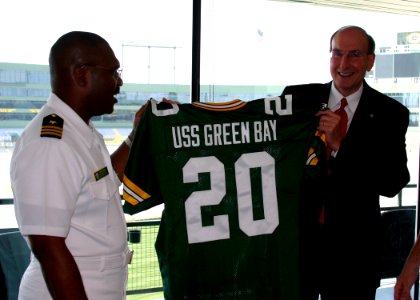 US Navy 070625-N-7163S-006 Prospective commanding officer of Precommssioning Unit (PCU) Green Bay (LPD 20) Cmdr. Cal Slocumb and Green Bay resident Rick Beverstein admire a jersey anticipating the commissioning of USS Green Bay photo