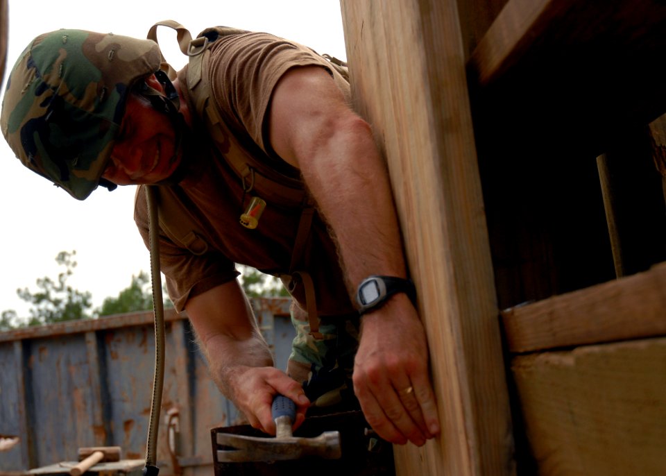US Navy 070626-N-3857R-008 Lt. j.g. Raymond Fletcher attached to Naval Mobile Construction Battalion (NMCB) 1 gives a helping hand to the timber tower build crew at Camp Shelby