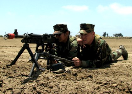 US Navy 070627-N-8547M-003 Engineers Aide 3rd Class Marie Buencilla and Equipment Operator 3rd Class Derek Prez, of Naval Mobile Construction Battalion (NMCB) 5, man a M240B machine gun