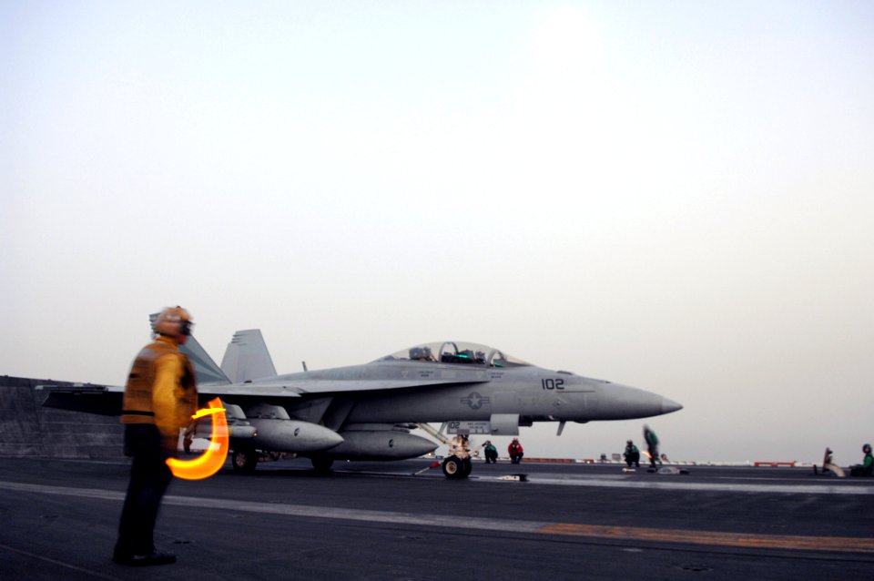 US Navy 070626-N-3729H-038 An F-A-18F Super Hornet assigned to the Black Knights of Strike Fighter Squadron (VFA) 154 is directed onto the catapult by a flight deck